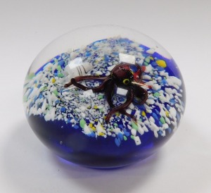 An art glass paperweight, decorated internally with an octopus, starfish and a shell, on a sea bed and blue ground, bears paper label to base, B2024, 8.5cm diameter. - 3