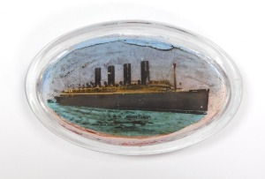 An early 20thC oval glass paperweight, decorated with the R.M.S. Mauretania, in silhouette profile, 11cm wide. - 3