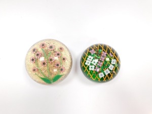 A Perthshire floral paperweight, decorated with trailing flowers on a trellis, green ground, underside dated cane for 1992, 8.5cm diameter, and a further paperweight, decorated with pink millefiori flowers, green stems and leaves against a gold aventurine - 4