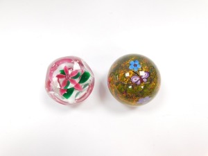 A Selkirk faceted glass paperweight, enclosing a single five petal pink flower and air bubbles, etched mark, dated 1997, 7cm diameter, and a further Selkirk butterfly paperweight, decorated with a butterfly and flowers, against a mottled moss ground, etch - 4