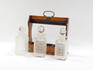 A 19thC oak tantalus, the oak case fitted with three cut glass decanters, and brass cap ends and swing handle support, with key, 35cm high, 34cm wide, 11cm deep. - 3
