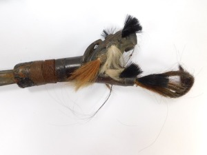 A Borneo Dayak Mandau, with a carved wooden bi-form handle set with animal hair, copper and wire bound, the blade of curved, plain form, in a bamboo sheath with carved and bound detailing, set to the rear pouch with animal's hair, enclosing a Langgei Puai - 4