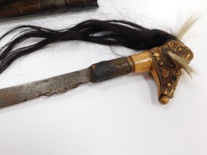 A Borneo Dayak Mandau, with a carved Aso head bone handle set with animal hair, metal and wire bound, the blade of curved, pierced and engraved form, in a wooden sheath with carved decoration and metal binding, set to the rear with a leather pouch, lackin - 3