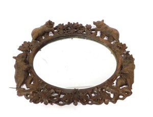 A 19thC wooden Black Forest oval wall mirror, the mirror plate in a carved frame of oak leaves, and four bears at intervals, 100cm high, 110cm wide. (AF) - 6