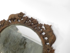 A 19thC wooden Black Forest oval wall mirror, the mirror plate in a carved frame of oak leaves, and four bears at intervals, 100cm high, 110cm wide. (AF) - 7