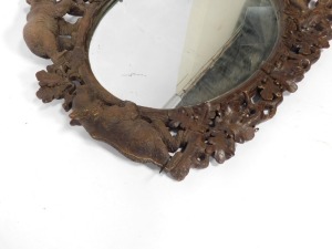 A 19thC wooden Black Forest oval wall mirror, the mirror plate in a carved frame of oak leaves, and four bears at intervals, 100cm high, 110cm wide. (AF) - 9