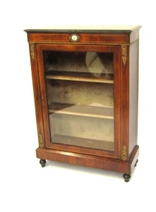 A Victorian walnut pier cabinet, the ebonised edged top over a glazed door, enclosing two shelves, raised on a plinth base and turned ebonies feet, 107cm high, 76cm wide, 30cm deep.