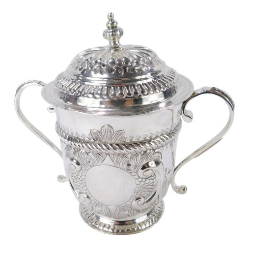 A George V Britannia silver copy of a seventeenth century porringer, of twin handled, covered form, with fluted and engraved decoration, oval vacant reserve, engraved No 131, Harry Freeman, London 1913, 12&frac12;oz, 17cm high.