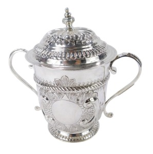A George V Britannia silver copy of a seventeenth century porringer, of twin handled, covered form, with fluted and engraved decoration, oval vacant reserve, engraved No 131, Harry Freeman, London 1913, 12&frac12;oz, 17cm high.