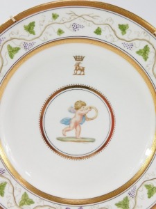 A pair of late 19thC Wedgwood porcelain plates, painted by J Thorley, with cherubs, one holding a staff and crosier, the other a ring, beneath a gilt crest of a goat beneath a coronet, believed to be Duke of Bedford crest, within a repeating vine border, - 2