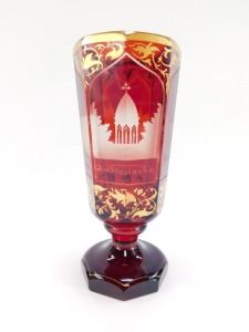 A Bohemian late 19thC ruby flashed glass vase, of octagonal footed form, 'Andenton von Marenbad', together with panels engraved with buildings, comprising Kreuzbrunn, Allesbadhaus, Ambrosinsbr., the ground over gilded with scrolling leaves, 19cm high. - 4