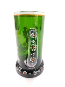 A late 19thC German green glass tankard, enamel decorated with an elfin figure holding a stein above a banner with hops and barley, reading "Dein Wohl Mein Liebchen" above a floral decorated foot, 16.5cm high. - 4