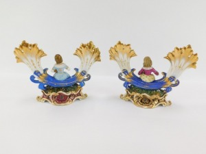 A pair of early 19thC Fischer & Mieg porcelain cornucopia vases, each encrusted with flowers and centred with a seated figure of a girl flower seller, raised on a naturalistic ground and rococo scroll base, one stamped CF324, the other F&M, 22cm wide. (AF - 4
