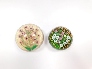A Perthshire floral paperweight, decorated with trailing flowers on a trellis, green ground, underside dated cane for 1992, 8.5cm diameter, and a further paperweight, decorated with pink millefiori flowers, green stems and leaves against a gold aventurine - 2