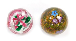 A Selkirk faceted glass paperweight, enclosing a single five petal pink flower and air bubbles, etched mark, dated 1997, 7cm diameter, and a further Selkirk butterfly paperweight, decorated with a butterfly and flowers, against a mottled moss ground, etch - 2
