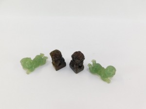 A pair of Chinese hard stone seals, modelled as Dogs of Fo, 93mm high, together with a pair of jadeite figures of recumbent children, 5cm wide. (4) - 4