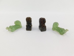 A pair of Chinese hard stone seals, modelled as Dogs of Fo, 93mm high, together with a pair of jadeite figures of recumbent children, 5cm wide. (4) - 5