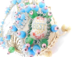 A George V Coronation sweetheart pin cushion, 20thC with a portrait of The King, and 'With Best Wishes' to the shoulders, otherwise decorated with wirework and beading, 16cm wide. - 4