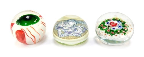 A Murano Azelaic style paperweight, decorated with Neptune, bears paper label, 10cm wide, a concentric millefiori paperweight, 10cm wide, and a zombie eye paperweight. (3)