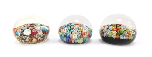 Three millefiori glass paperweights, two with mixed tight canes, each 6cm wide.