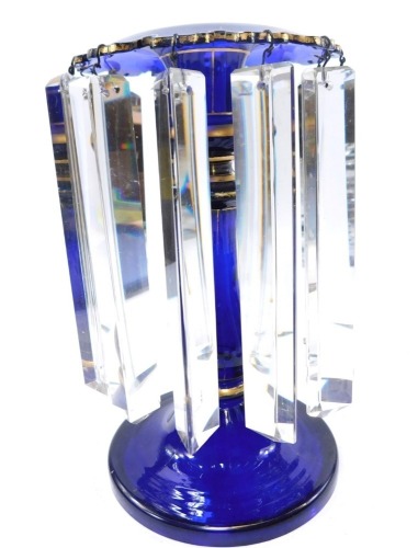 A Victorian Bristol blue glass lustre, with gilt highlights and prismatic drops, 25cm high.