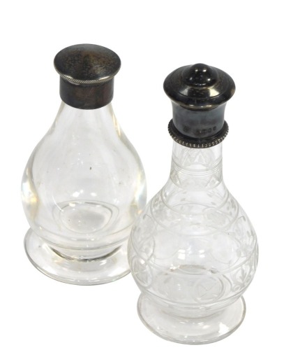 A Victorian glass communion bottle, of baluster form, with engraved decoration, silver mount and lid, Cox and Sons, London 1894, and a communion bottle of plain baluster form, with silver mount and screw lid, London 1962. (2)