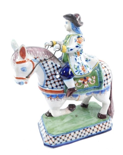 A Delft ware polychrome figure of a rider on horseback, raised on a canted rectangular base, signed Roos, 21cm wide.