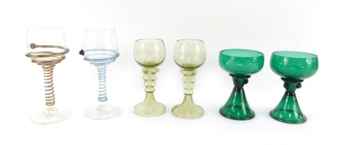 A pair of wine glasses, one decorated with silver lustre spiral strap work, the other with turquoise blue strap work, 17.5cm high, together with a pair of German green glass roemers, decorated with strawberry prunts, raised on a conical foot, 13cm high, a