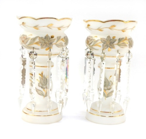 A pair of late 19thC milk glass lustres, gilt painted and gilt highlighted with flowers and scrolling leaves, with prismatic drops, 32.5cm high.