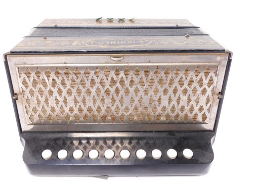 A Hohner accordion, ten button, in a gilt decorated black case.