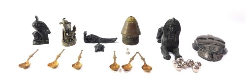 A hollow bronze figure of a recumbent Sphinx, Indian brass cast of a calf and cow being milked, further sculptures, brass anointing type coffee spoons, military shell cap and a hard stone scarab beetle, with hieroglyphics to the underside. (a quantity)