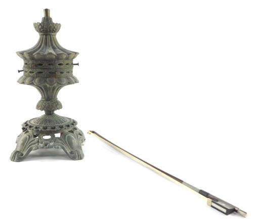 A Victorian cast metal oil lamp base, converted to electricity, shade lacking, together with a violin bow. (2)
