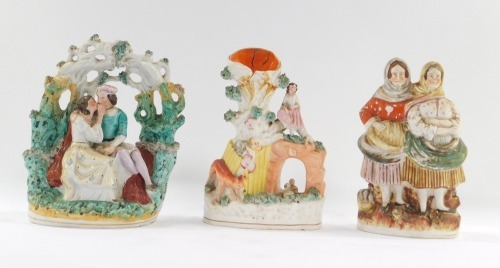 Three Staffordshire flat back figure groups, comprising a couple with vine arch back, 22cm high, spill vase, 22cm high, and a two person figure group of fish wives, 22cm high. (3, AF)