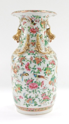 A late 19thC Cantonese porcelain famille rose vase, of shouldered, ovoid form, decorated with birds, butterflies and flowers, with gold dog of fo handles and dragons, with a flared rim top, 35cm high.