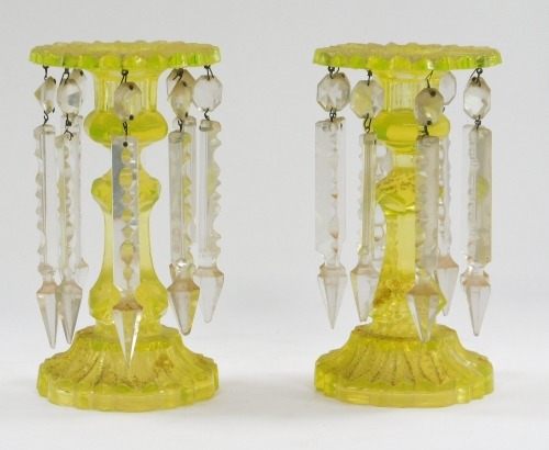 A pair of lime green glass lustres, each with a flared top and eight prismatic lustres, on a tapered stem, 20cm high.