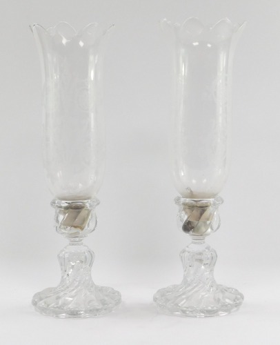A pair of late 20thC cut glass storm lamps, the trumpet shades with etched design floral body, on spital twist stem bases, 36cm high.