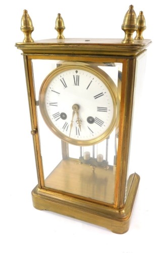 A 19thC brass four glass mantel clock, with four acorn finial top on four glazed and panelled doors, with white ceramic dial bearing Roman numerals, eight day, twin barrel movement with bell strike, and mercury pendant, 29cm high, 15cm wide, 10cm deep.