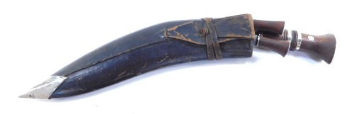 A Middle Eastern Kukri knife, the arched blade with a two part wooden handle, with two smaller sharpening knives, 43cm long.