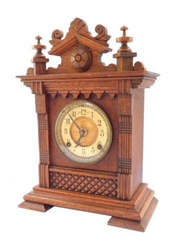 An late 19thC oak cased mantel clock, Ansonia Clock Co, Salem, Mass., brass dial with chapter ring bearing Arabic numerals, eight day movement with coil strike, the case with arched pediment, 38cm high, 25cm wide, 12cm deep.