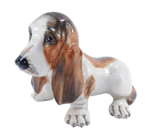 An Italian pottery figure of a basset hound, signed S M, 20cm high. (AF)