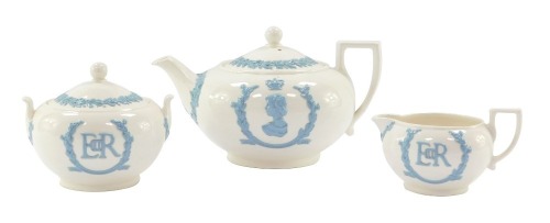 A Wedgwood Coronation 1953 tea set, white ground with blue raised relief, comprising teapot, sugar bowl and cover, and milk jug.