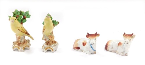 Animal figures, comprising a pair of Samson Chelsea porcelain canaries, 11cm high, and a pair of cows, 5cm high. (4)