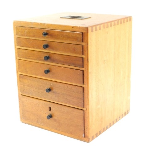 A 20thC wooden dentistry cabinet, with arrangement of six graduated drawers with mahogany handles and brass recessed top handle, 31cm high, 25cm wide, 24cm deep.
