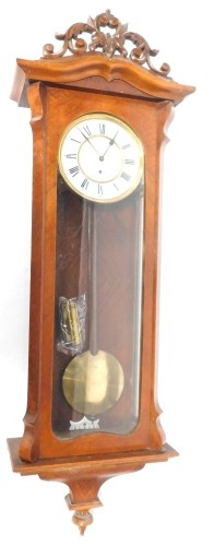 A late 19thC walnut cased Vienna wall clock, circular enamel dial bearing Roman numerals, thirty hour movement, the case with arched pediment and glazed door, with pendulum, weight and key, 118cm high, 40cm wide, 18cm deep.