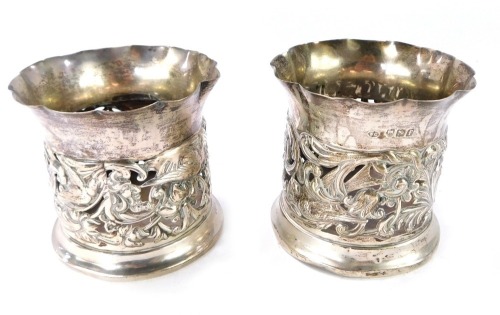 A pair of Edward VII silver bottle holders, with pierced and embossed decoration of birds, flowers and foliate scrolls, William Comyns & Sons, London 1901, 5&frac14;oz. (AF)