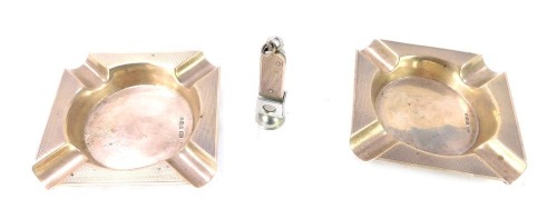 Two silver ashtray and a silver cigar cutter, the ashtray of engine turned decoration, Sheffield 1958, and the cutter, Birmingham 1982, 5&frac14;oz. (3)