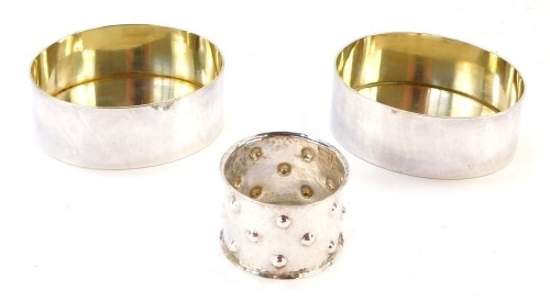 A German napkin ring, with hammered decoration, white metal, stamped 835, together with a pair of oval containers, with gilt interiors, white metal, unmarked, 6&frac34;oz gross. (3)