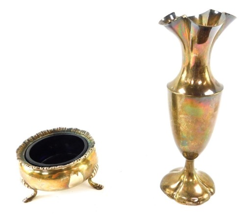 Two items of silver, comprising an Edward VII circular silver salt cellar, with fluted top and blue glass liner, raised on three cabriole legs and hoof feet, Birmingham 1903, 2&frac14;oz, and a silver flared rim vase, with weighted base, London, 5&frac14;oz all in. (2)