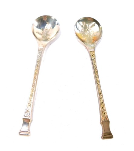 Two Queen Elizabeth II silver Christmas seal top spoons, one depicting carol singers, the other a Victorian ice skater, Peter Jackson, London 1975 and 1976, 2oz. (2)