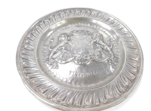 A late 19thC polished pewter dish, with fluted border and central coat of arms of the city of Plymouth, 23cm diameter.